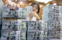 This undated file photo shows a banker checking dollars at Hana Bank's Counterfeit Notes Response Center in Seoul. (Yonhap)