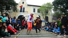 Foreign tourists enjoy a folk cultural activity in Hanoi (Photo: Nhan dan Newspaper)