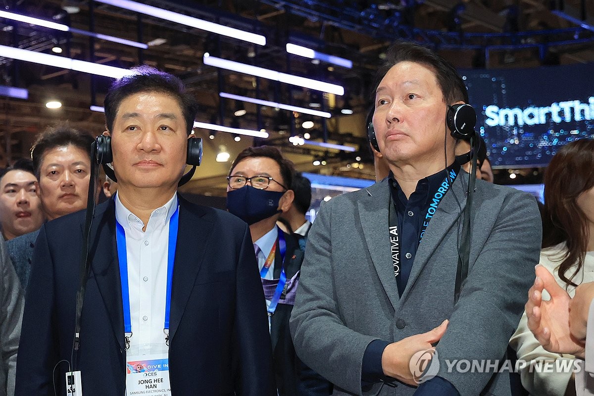 SK Group Chairman Chey Tae-won (R) tours Samsung Electronics Co.'s exhibition booth with Samsung Electronics Vice Chairman Han Jong-hee at the Las Vegas Convention Center at CES 2025 on Jan. 8, 2025. (Yonhap)