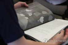 This file photo, taken July 11, 2019, shows a person reading a report by Amnesty International on sexual minorities in the South Korean military at a press conference in central Seoul. (Yonhap)