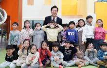 This undated photo, provided by the Seoul city government, shows Seoul Mayor Oh Se-hoon posing for a photo with young children at a playground cafe for children. (PHOTO NOT FOR SALE) (Yonhap)