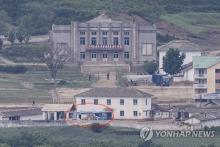 This file photo, taken May 30, 2023, from South Korea's border city of Paju, 37 kilometers northwest of Seoul, shows buses (circled red), presumed to be used at the Kaesong Industrial Complex, parked at a nearby North Korean border town. (Yonhap)