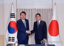 President Yoon Suk Yeol (L) and Japanese Prime Minister Fumio Kishida shake hands during their meeting in Washington, D.C., on July 10, 2024, on the sidelines of the North Atlantic Treaty Organization summit. (Yonhap)