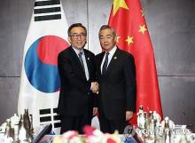 Foreign Minister Cho Tae-yul (L) shakes hands with his Chinese counterpart, Wang Yi, in Vientiane, Laos, on July 26, 2024. (Yonhap)