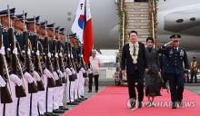 President Yoon Suk Yeol (L) and first lady Kim Keon Hee (C) arrive at Ninoy Aquino International Airport in Manila on Oct. 6, 2024, to begin a state visit to the Philippines. (Yonhap)