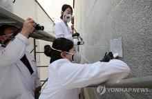 This undated file photo shows experts working to erase graffiti on the wall of Gyeongbok Palace in Seoul. (Yonhap)