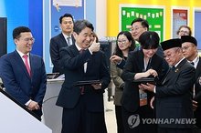 Acting President Lee Ju-ho (2nd from L) tours an exhibition booth at the Jeju International Convention Center on Jeju Island on May 13, 2025, where the education ministers' meeting of the Asia-Pacific Economic Cooperation (APEC) members is taking place this week, in this photo provided by the education ministry. (PHOTO NOT FOR SALE) (Yonhap)