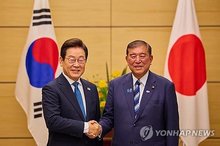 This Aug. 24, 2025, file photo shows President Lee Jae Myung (L) shaking hands with Japanese Prime Minister Shigeru Ishiba during their summit in Tokyo. (Yonhap)