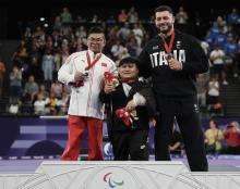 Malaysia's powerlifting athlete Bonnie Bunyau Gustin with silver medalist Peng Hu of China (left) and bronze medalist Telesca Donating of Italy (right) after winning the men’s up to 72kg final at the Paris 2024 Paralympic Games 