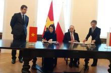 Deputy Minister of Foreign Affairs Nguyen Minh Hang (L) and Secretary of State at the Polish Foreign Affairs Władysław Teofil Bartoszewski sign the memorandum of understanding on strengthening bilateral diplomatic relations. (Photo: baochinhphu.vn)