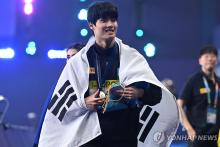 In this AFP photo, Hwang Sun-woo of South Korea celebrates during the medal ceremony after winning the men's 200-meter freestyle title at the World Aquatics Championships at the Aspire Dome in Doha on Feb. 13, 2024. (Yonhap)