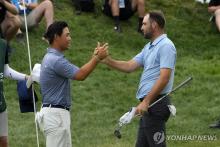 In this Associated Press photo, Tom Kim of South Korea (L) congratulates Scottie Scheffler of the United States after the American player won the Travelers Championship in a playoff at TPC River Highlands in Cromwell, Connecticut, on June 23, 2024. (Yonhap)