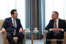 In this file photo, President Yoon Suk Yeol (L) speaks with Polish President Andrzej Duda during their meeting at a hotel in Warsaw ahead of a business forum on July 14, 2024. (Pool photo) (Yonhap)