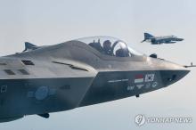 A KF-21 fighter jet prototype (front) flies alongside an F-4E jet in this file photo provided by the Air Force on May 12, 2024. (PHOTO NOT FOR SALE) (Yonhap)