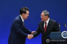 President Yoon Suk Yeol (L) shakes hands with Chinese Premier Li Qiang after holding a joint press conference with Japanese Prime Minister Fumio Kishida following their trilateral summit in Seoul on May 27, 2024, in this photo provided by Yoon's office. (PHOTO NOT FOR SALE) (Yonhap)