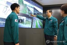 Prime Minister Han Duck-soo (2nd from R) talks with an official during a visit to the Han River Flood Control Office in Seoul on June 27, 2024, amid the monthlong rainy season. (Yonhap)