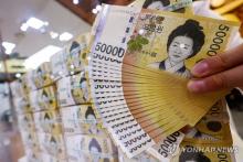 A clerk checks 50,000-won notes at a Seoul bank on July 17, 2024. (Yonhap)