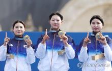 Jeon Hun-young, Lim Si-hyeon and Nam Su-hyeon of South Korea (L to R) form the number 10 with their index fingers and gold medals, after winning the gold medal in the women's archery team event at the Paris Olympics at Invalides in Paris on July 28, 2024. It was South Korea's 10th consecutive gold medal in the event. (Yonhap)