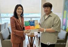 You Hye-mi (L), senior presidential secretary for low birth rate issues, delivers a congratulatory gift from President Yoon Suk Yeol to Kim Jun-young (R), the father of newborn quintuplets, at a hospital in Seoul on Sept. 22, 2024, in this photo provided by the presidential office. (PHOTO NOT FOR SALE) (Yonhap)