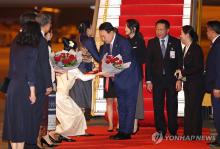 President Yoon Suk Yeol (C) receives a bouquet upon arrival at Wattay International Airport in Vientiane, Laos, on Oct. 9, 2024. (Yonhap)