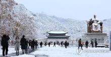 People walk in Gwanghwamun Square in Seoul as heavy snow piled up in the city on Nov. 27, 2024. (Yonhap)