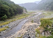 Waters upstream of the Obong Reservoir in Gangneung, 210 kilometers east of Seoul, flow under falling rain on Sept. 13, 2025. (Yonhap)