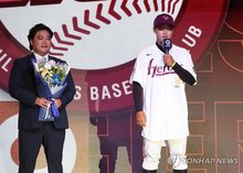 Bugil High School pitcher Park Jun-hyun (R) speaks after being selected first overall by the Kiwoom Heroes at the annual Korea Baseball Organization (KBO) draft at Lotte Hotel World in Seoul on Sept. 17, 2025. Park is joined on the stage by his father and former KBO All-Star Park Sok-min. (Yonhap)