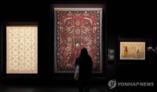 Visitors look at Islamic carpets on display at the exhibition "Islamic Art: A Journey of Splendor" at the National Museum of Korea in central Seoul on Nov. 21, 2025. (Yonhap)