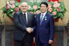 Vietnamese State President Luong Cuong (R) shakes hands with Russian Prime Minister Mikhail Mishustin. (Photo: VNA)