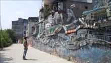 A visitor looks at works at Phuc Tan Art Street - a community creative space. (Photo: VNA)