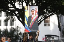 A person demonstrates by holding up a poster of Venezuelan President Nicolás Maduro near the Miraflores Palace in Caracas, the capital of Venezuela, on January 3, 2026. (ANTARA)