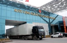 ehicles carrying goods clear customs through Mong Cai (Vietnam) - Dongxing (China) border gate at Bac Luan II bridge area. (Photo: VNA)