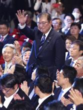 Former Japanese Defense Minister Shigeru Ishiba waves to fellow Liberal Democratic Party lawmakers at the ruling party's headquarters in Tokyo on Sept. 27, 2024, after winning the party's presidential election in a runoff vote. (Kyodo)