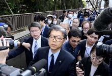 Lawyer Nobuya Fukumoto (front) is surrounded by journalists in front of the Tokyo District Court in the Japanese capital on March 25, 2025, after the court ordered that his client, the Unification Church, be dissolved, a decision that will deprive the controversial organization, criticized for soliciting financially ruinous donations from its members, of its status as a religious corporation with tax advantages. (Kyodo)