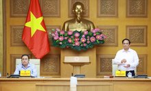 Prime Minister Pham Minh Chinh (R) speaks at the conference (Photo: VNA)