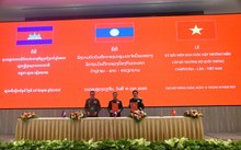 The defence ministers of Vietnam, Laos and Cambodia sign the minutes of their annual meeting in Vientiane on October 15. (Photo: VNA)