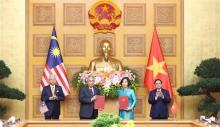 Prime Minister Pham Minh Chinh (R) and his Malaysian counterpart Dato’ Sri Ismail Sabri bin Yaakob (L) witness the exchange of cooperation agreement between VNA and Bernama (Photo: VNA)