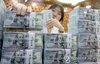 This undated file photo shows a banker checking dollars at Hana Bank's Counterfeit Notes Response Center in Seoul. (Yonhap)